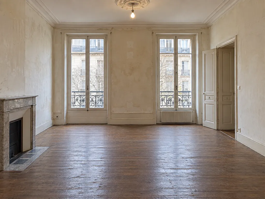 Le salon vide, avant aménagement, avec ses murs à rafraîchir et son parquet ancien.